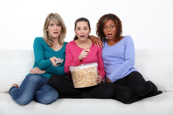Trzy kobiety przestraszony siedział na kanapie oglądając film — Zdjęcie stockowe