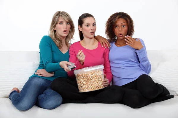 Tři ženy jíst popcorn, při sledování filmu — Stock fotografie
