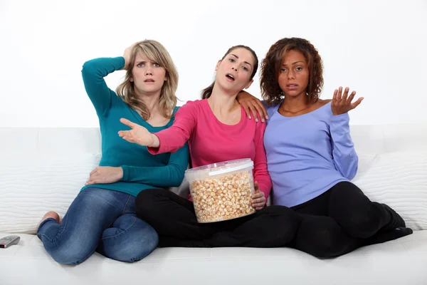 Друзья смотрят телевизор и едят попкорн — стоковое фото
