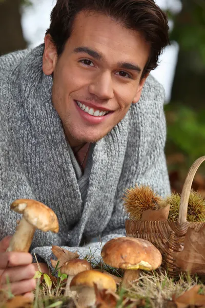Człowiek, zbieranie grzybów i kasztany w lesie — Zdjęcie stockowe