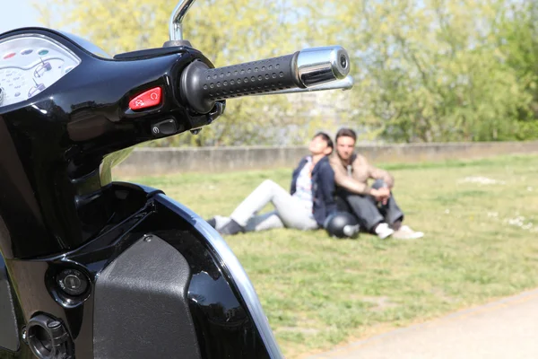 Parked scooted next to couple — Stock Photo, Image