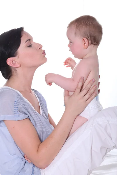 Женщина целует своего ребенка — стоковое фото