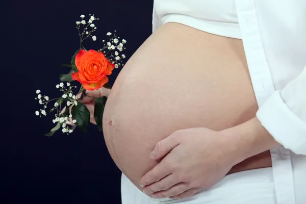 Беременная женщина держит цветок — стоковое фото