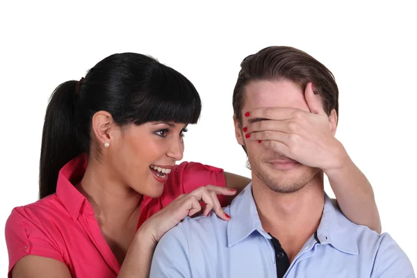 Young woman covering a man's eyes — Stock Photo, Image