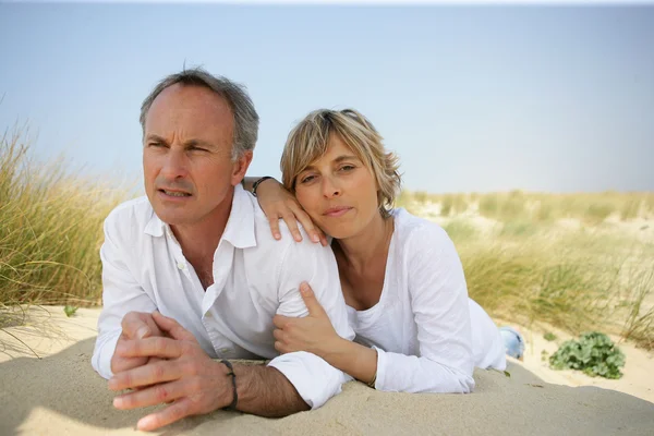 Couple lying in a sand dune — Stock Photo, Image