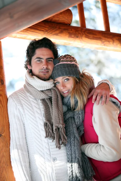 Couple stood hugging on chalet patio — Stock Photo, Image