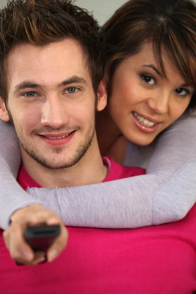 Couple with a remote control — Stock Photo, Image