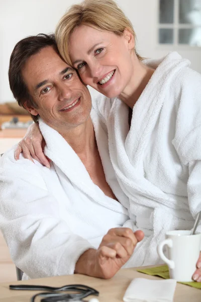 Пара, одетая в купальные халаты на кухне — стоковое фото