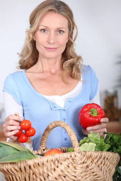 Esposa sosteniendo pimienta y tomates —  Fotos de Stock