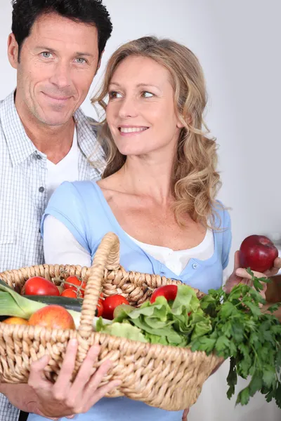 Esposa olhando para o marido com cesta de legumes . — Fotografia de Stock