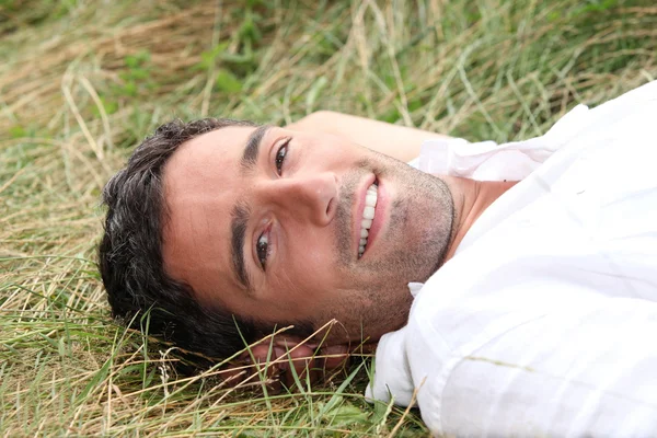 Man laying on his back in field — Stock Photo, Image