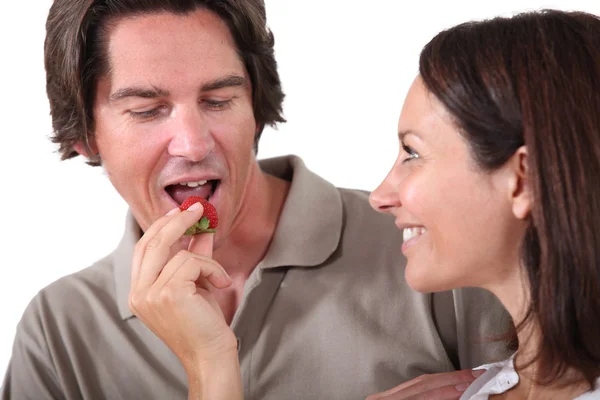 Woman offering piece of fruit to man — Stock Photo, Image