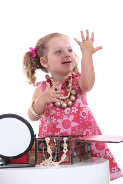 Girl playing with her mother's jewellery clipart