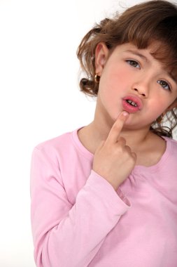 Young girl touching her chin with her finger clipart