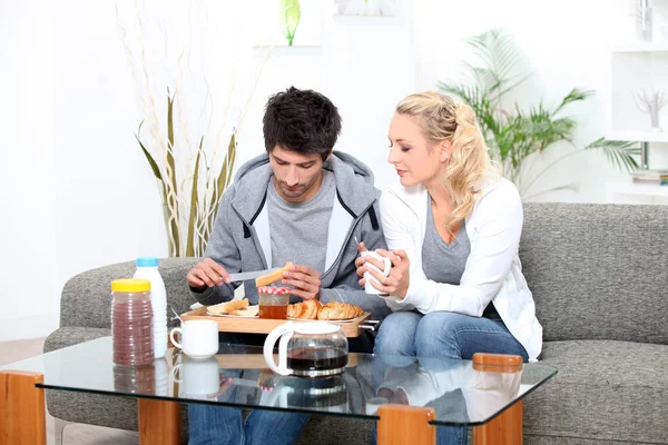 Coppia che fa colazione nel loro soggiorno — Foto Stock