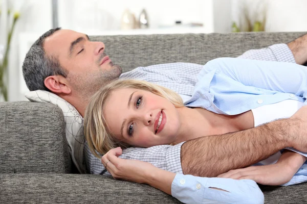 Couple lying on the couch — Stock Photo, Image