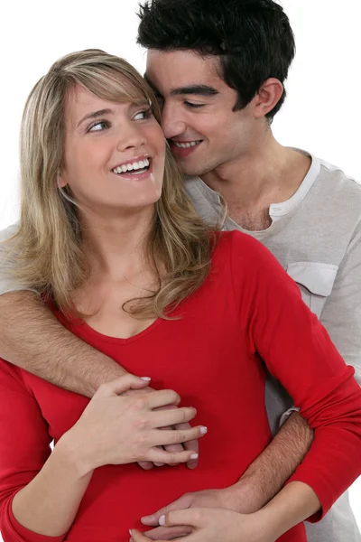 Jovem casal feliz abraçando contra o fundo do estúdio — Fotografia de Stock