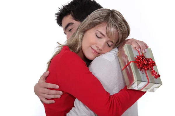 Jeune homme tenant petite amie dans les bras après avoir donné cadeau — Photo
