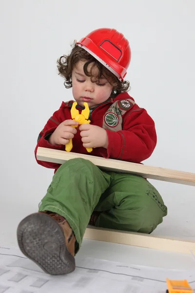 Criança fingindo ser um trabalhador da construção civil — Fotografia de Stock