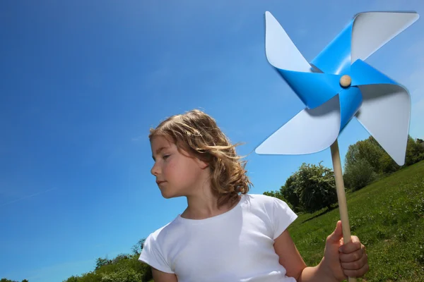 Little girl stood in filed with toy windmill — Stock Photo, Image