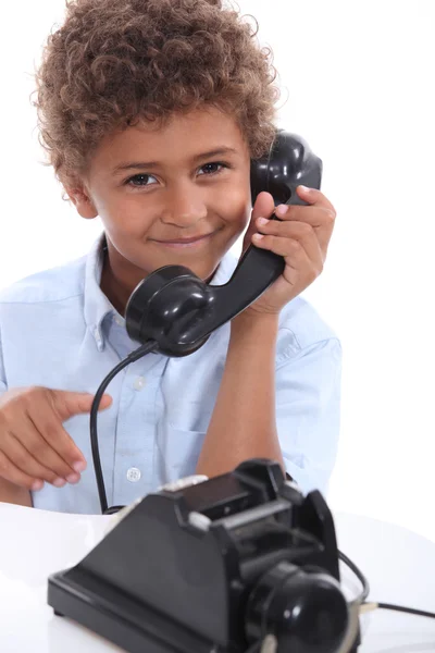 Мальчик со старомодным телефоном — стоковое фото