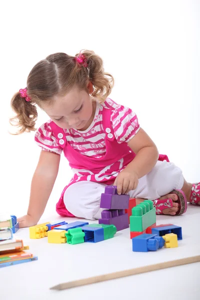 Liten flicka spelar med byggstenar — Stockfoto