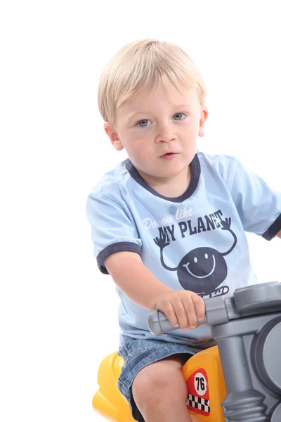 Милая блондинка на игрушечном велосипеде — стоковое фото
