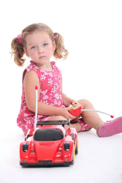 Ung flicka som leker med en fjärrkontroll bil — Stockfoto