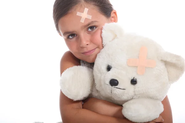 Dívka a teddy s omítkou — Stock fotografie