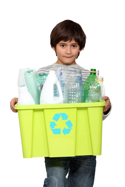 Garoto segurando banheira de reciclagem cheia de garrafas de plástico vazias — Fotografia de Stock