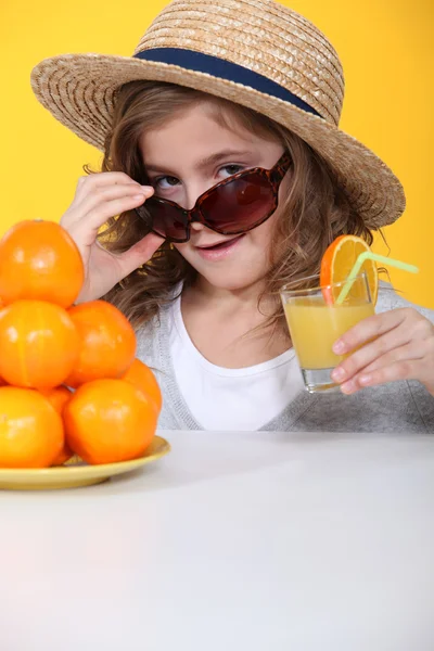 Little girl with freshly squeezed orange juice — Stock Photo, Image