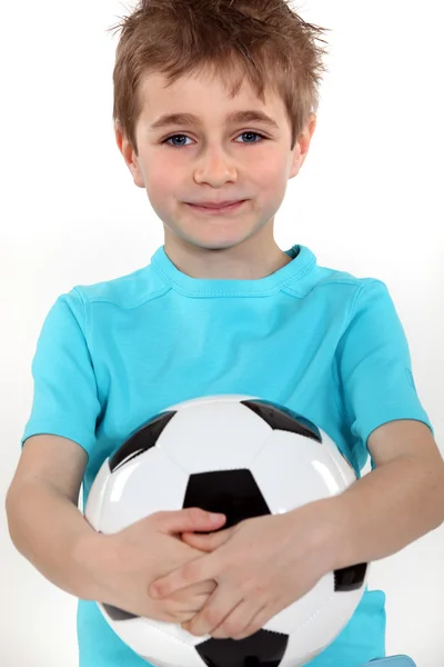 Junge hält einen Fußball in der Hand — Stockfoto