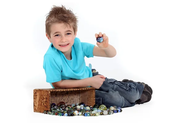 Little boy playing with marbles — Stock Photo, Image