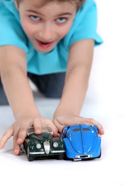 Niño jugando con coches de juguete —  Fotos de Stock
