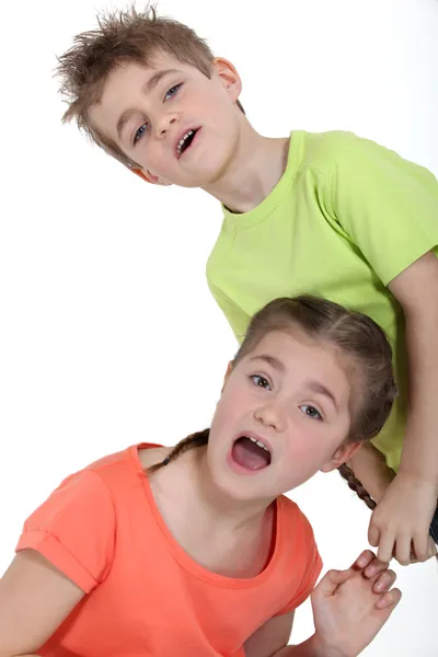 Jeune garçon tirant la tresse de sa sœur — Photo