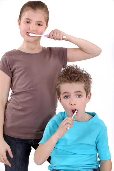 Niño y niña cepillándose los dientes —  Fotos de Stock