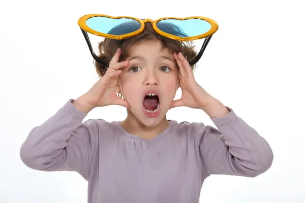 Petite fille choquée portant des lunettes comiques — Photo