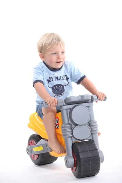 Portrait of a child on a toy motorbike Stock Image