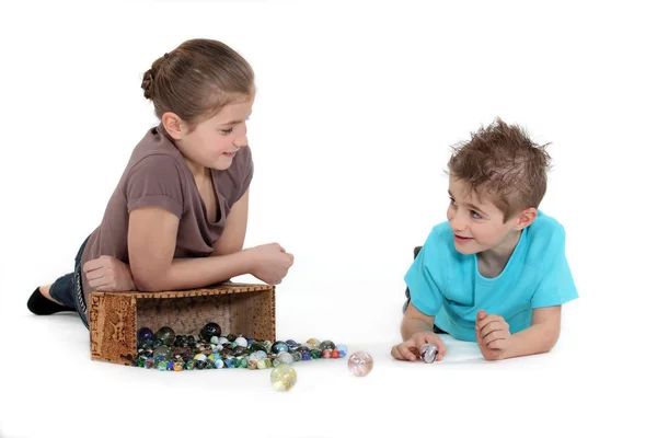 Kinder spielen Murmeln Stockbild