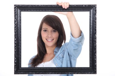 Teenage girl behind a painting frame clipart