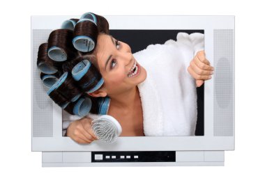 Woman popping out the TV with hairroller on. clipart