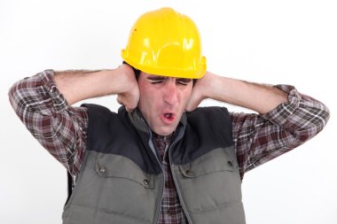 A construction worker covering his ears. clipart
