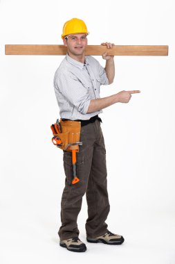 Carpenter carrying plank over his shoulder pointing at something clipart