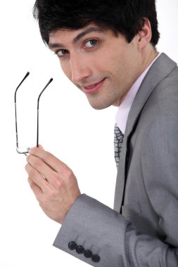 Businessman holding his glasses clipart