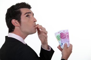 Businessman wondering what to do with his money clipart