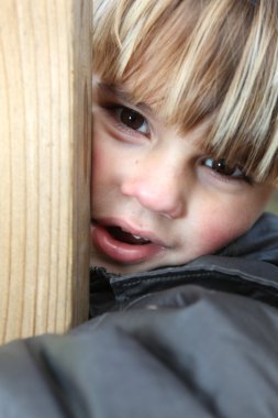 Close-up little blond boy playing outside clipart