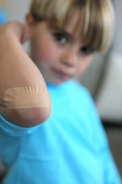 Little boy with plaster on his elbow clipart