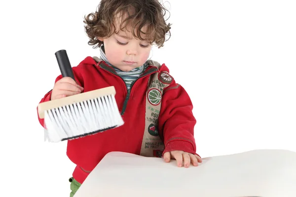 Boy pasting wallpaper with a brush — Stock Photo, Image