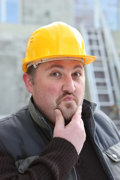 Constructor pensativo frotando barbilla — Foto de Stock