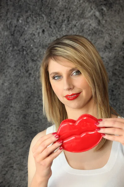 Blond woman holding comedy plastic lips — Stock Photo, Image